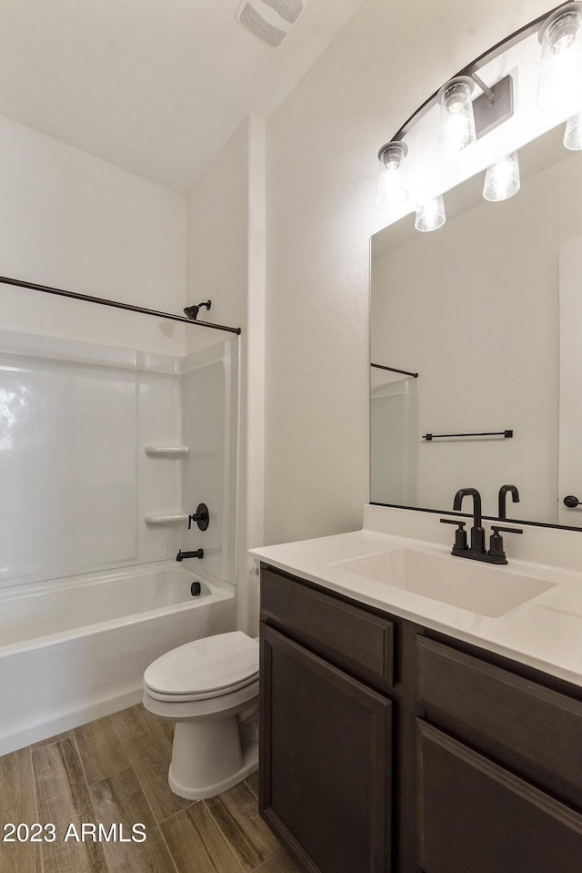 full bathroom featuring hardwood / wood-style flooring, vanity, toilet, and shower / bathing tub combination