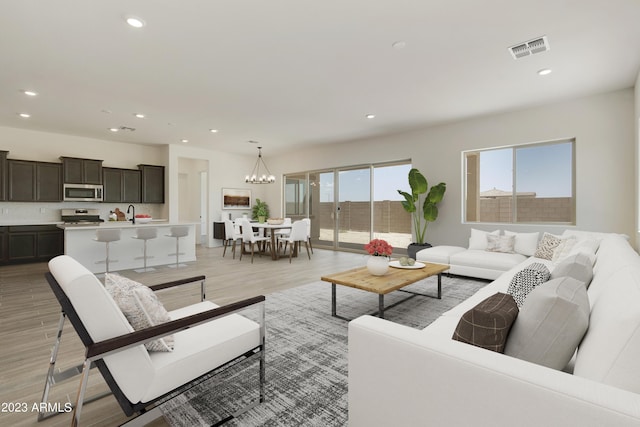 living room with an inviting chandelier and light hardwood / wood-style flooring