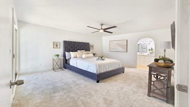 bedroom featuring light colored carpet, connected bathroom, and ceiling fan