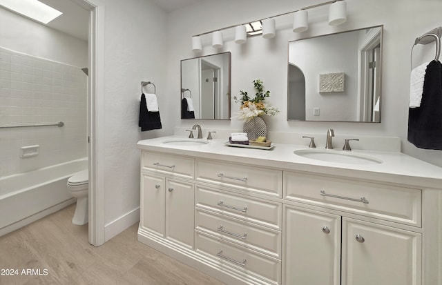 full bathroom featuring toilet, hardwood / wood-style flooring, bathing tub / shower combination, and vanity