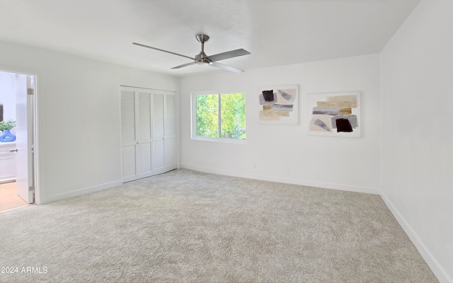 unfurnished bedroom featuring light carpet, ceiling fan, and a closet