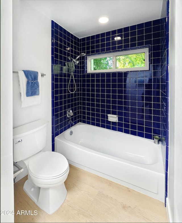 bathroom featuring toilet and tiled shower / bath combo