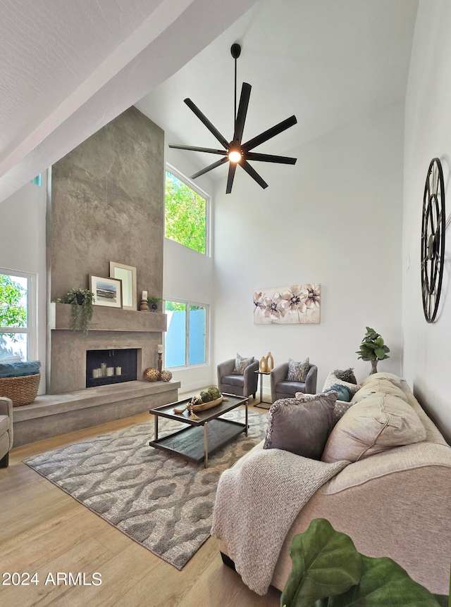 living room featuring a fireplace, high vaulted ceiling, a wealth of natural light, and ceiling fan