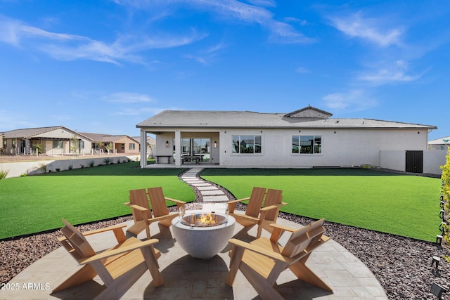 back of house with fence, a fire pit, a yard, and a patio