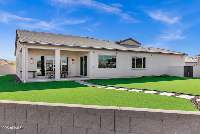 rear view of property with a patio, a yard, fence private yard, and stucco siding