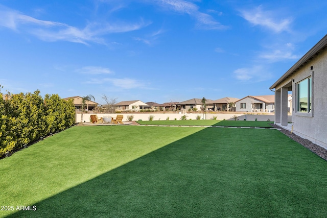 view of yard featuring fence and a residential view