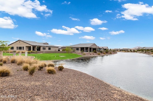view of front facade with a residential view, a front yard, and a water view