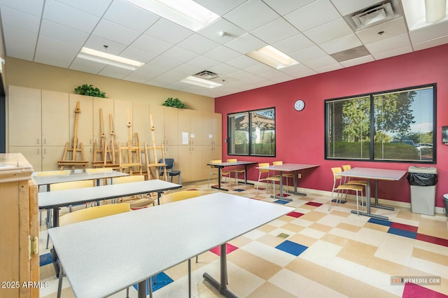 rec room with tile patterned floors, visible vents, and a paneled ceiling