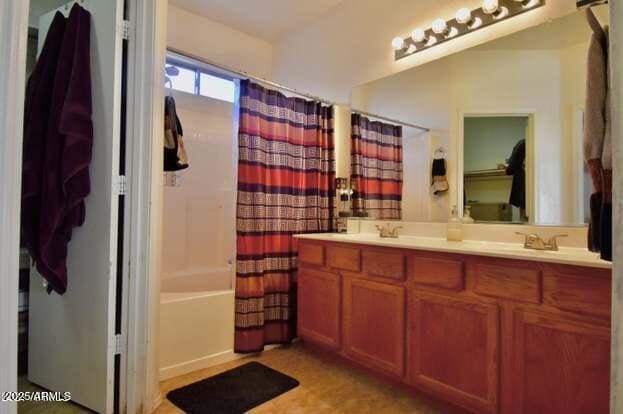 full bath featuring double vanity, a sink, and shower / bath combination with curtain