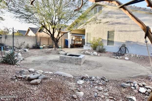 exterior space featuring a fire pit and fence