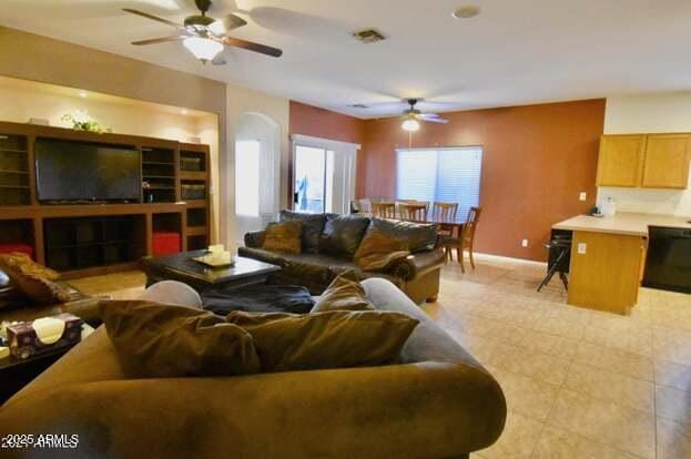 living area featuring visible vents, baseboards, and a ceiling fan