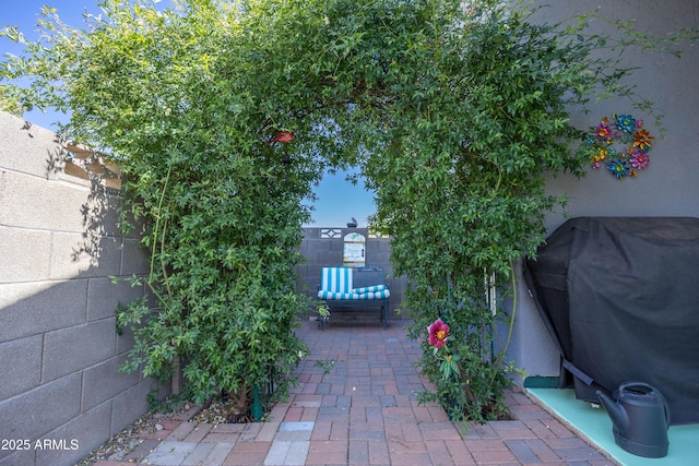 view of patio with fence and a grill