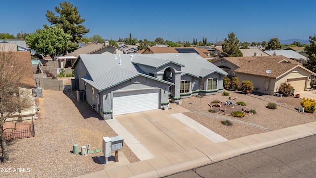 traditional-style home with central AC, fence, an attached garage, driveway, and a residential view