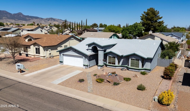 view of front of house with concrete driveway, an attached garage, a residential view, and stucco siding