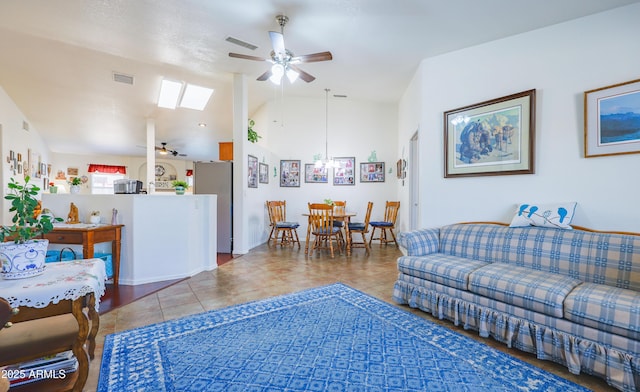tiled living area featuring a ceiling fan, visible vents, and lofted ceiling with skylight