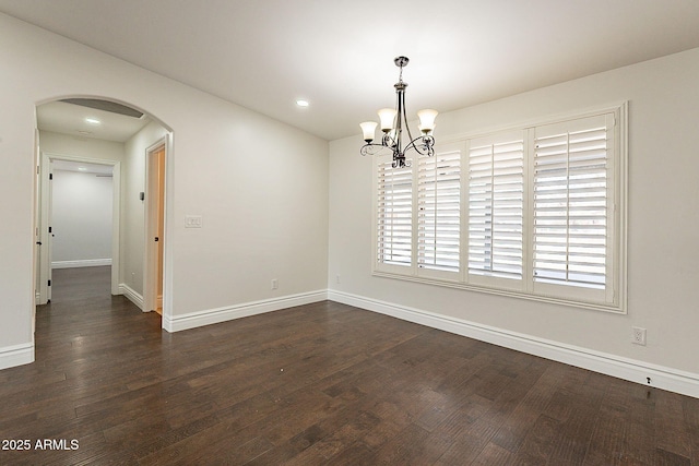 empty room featuring dark hardwood / wood-style floors and a chandelier