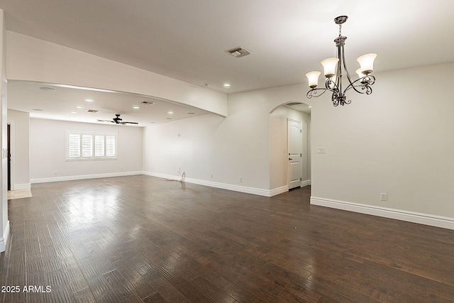 spare room featuring dark hardwood / wood-style floors and ceiling fan with notable chandelier