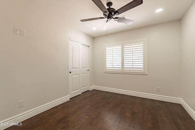 empty room with dark hardwood / wood-style floors and ceiling fan