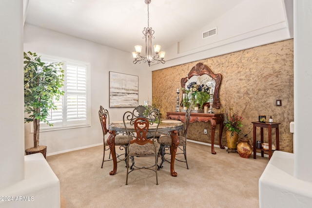 dining area with light carpet, vaulted ceiling, and a chandelier