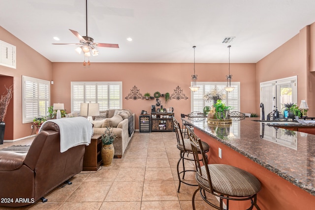 living room featuring ceiling fan, light tile patterned flooring, and sink