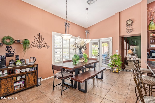 dining area featuring light tile patterned flooring and high vaulted ceiling