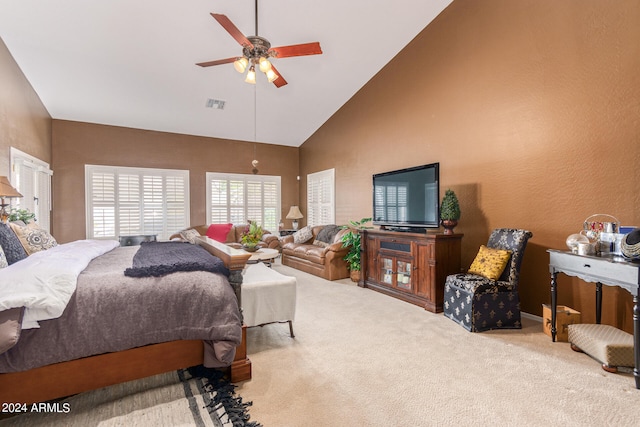 carpeted bedroom with ceiling fan and high vaulted ceiling