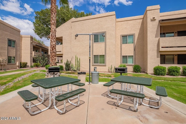 view of community with a patio and a lawn