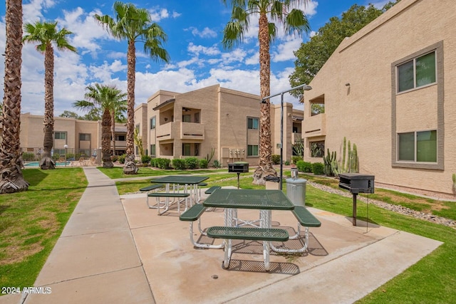 view of property's community with a patio and a lawn