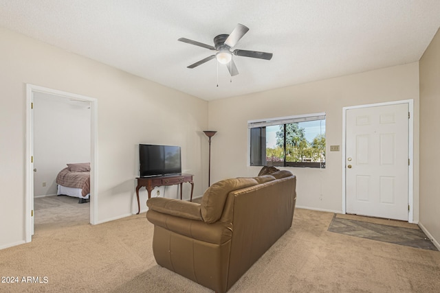 carpeted living room with ceiling fan