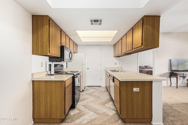 kitchen featuring light carpet, black appliances, sink, and kitchen peninsula