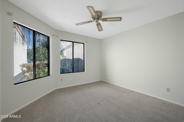 carpeted spare room with a textured ceiling and ceiling fan