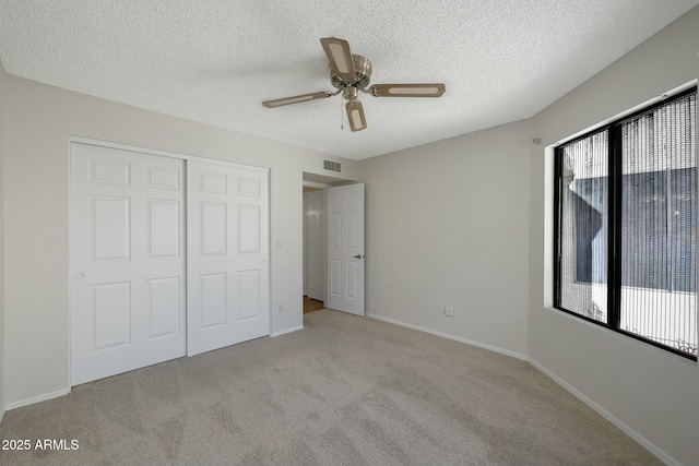 unfurnished bedroom with multiple windows, light carpet, a closet, and ceiling fan