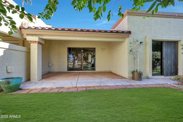 back of house with a patio area and a lawn