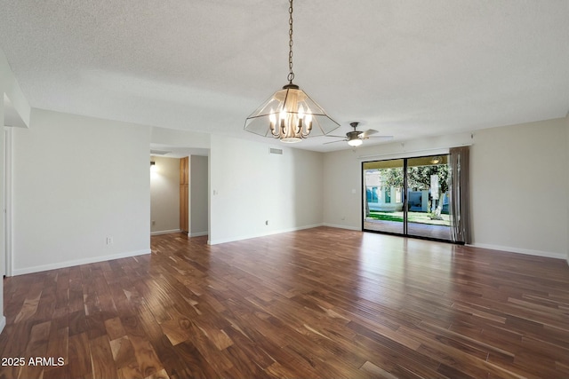 spare room featuring ceiling fan with notable chandelier, dark hardwood / wood-style flooring, and a textured ceiling