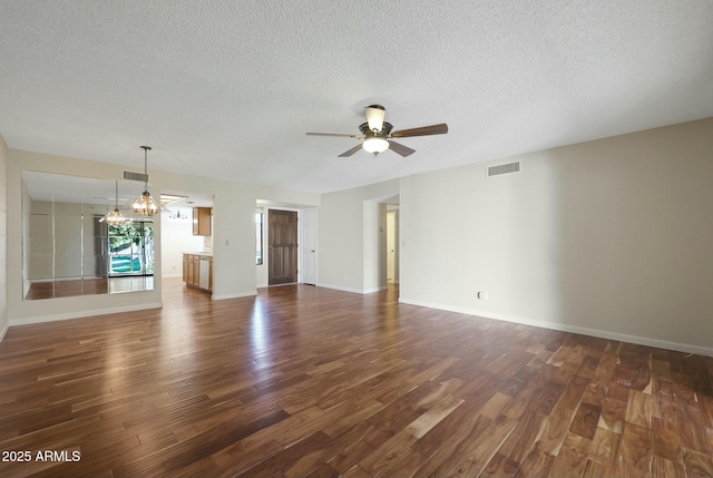 unfurnished living room featuring a textured ceiling, ceiling fan with notable chandelier, and dark wood-type flooring