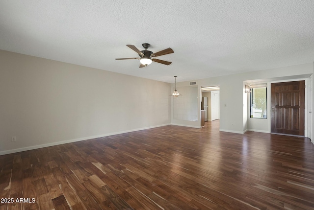 empty room featuring a textured ceiling, dark hardwood / wood-style flooring, and ceiling fan with notable chandelier