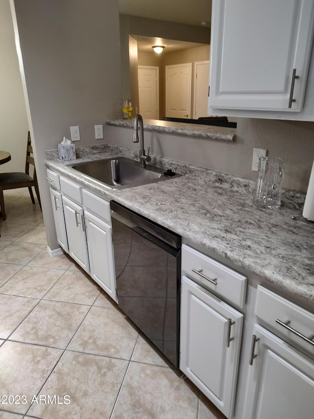 kitchen with sink, white cabinets, black dishwasher, and light tile patterned flooring