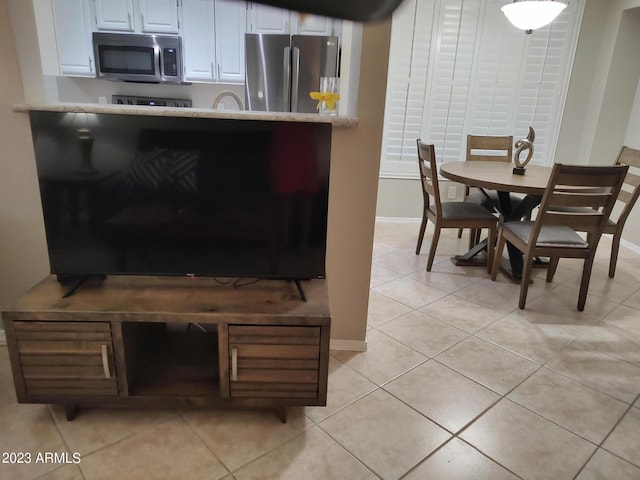 interior space featuring white cabinetry, appliances with stainless steel finishes, and light tile patterned flooring