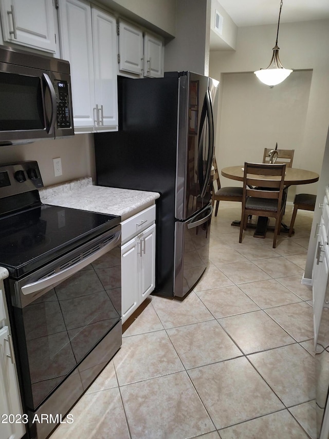 kitchen featuring light tile patterned floors, electric range, white cabinetry, and hanging light fixtures