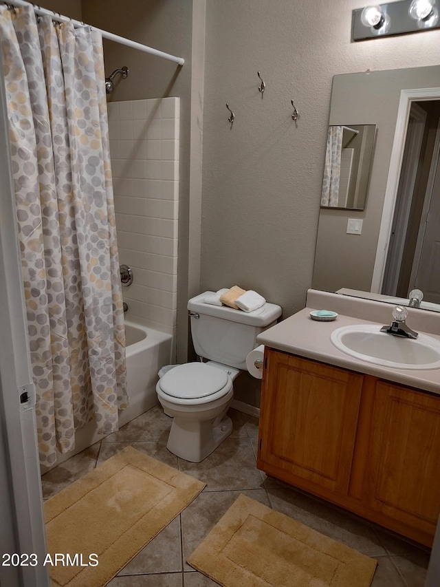 full bathroom with tile patterned floors, toilet, shower / bath combo with shower curtain, and vanity