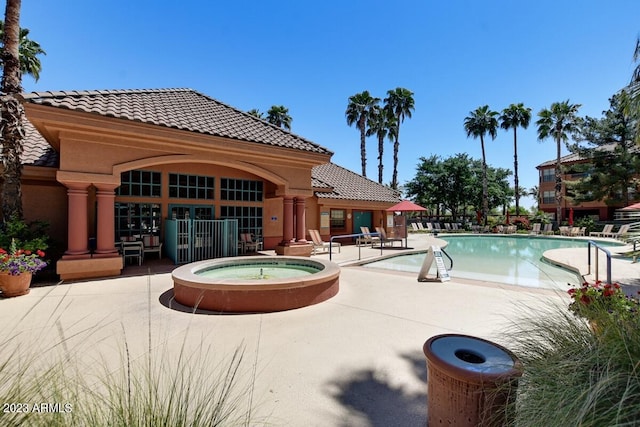 view of swimming pool with a patio and an in ground hot tub