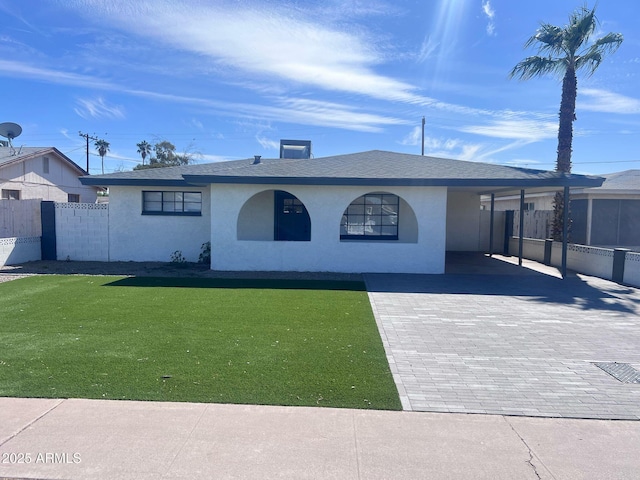 single story home with stucco siding, an attached carport, fence, decorative driveway, and a front yard