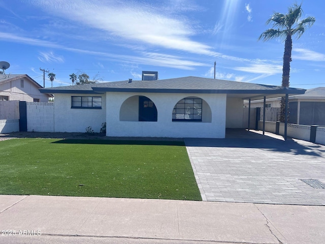 ranch-style home featuring a front yard, decorative driveway, fence, and stucco siding