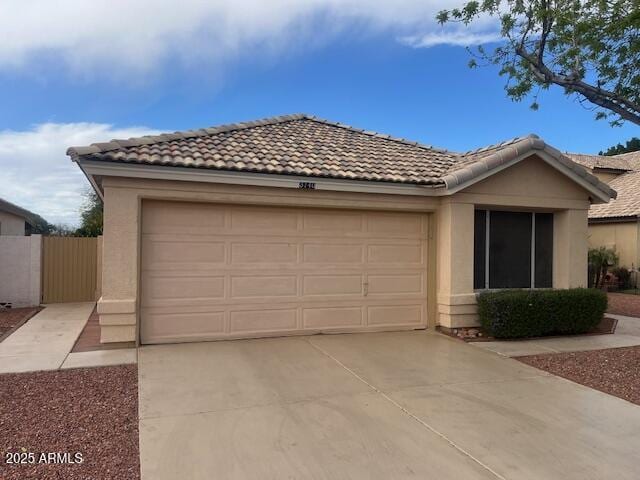 ranch-style home with stucco siding, driveway, fence, an attached garage, and a tiled roof