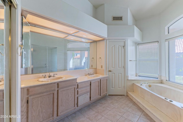 bathroom with tile patterned flooring, vanity, separate shower and tub, and a wealth of natural light