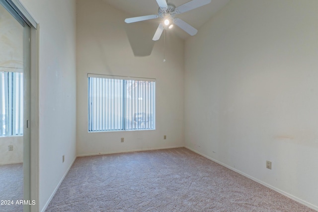 carpeted empty room featuring ceiling fan and lofted ceiling