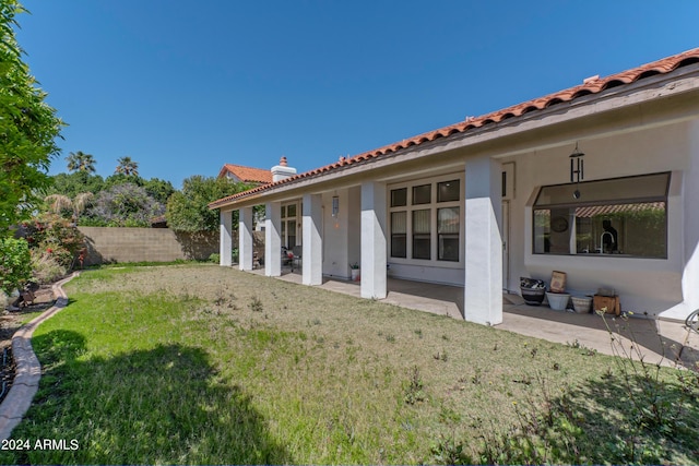 rear view of house with a yard and a patio