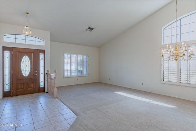 foyer entrance with light colored carpet and a notable chandelier