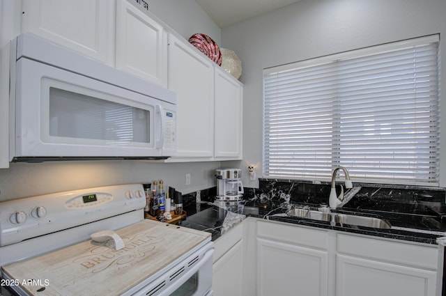 kitchen with sink, white cabinets, white appliances, and dark stone counters