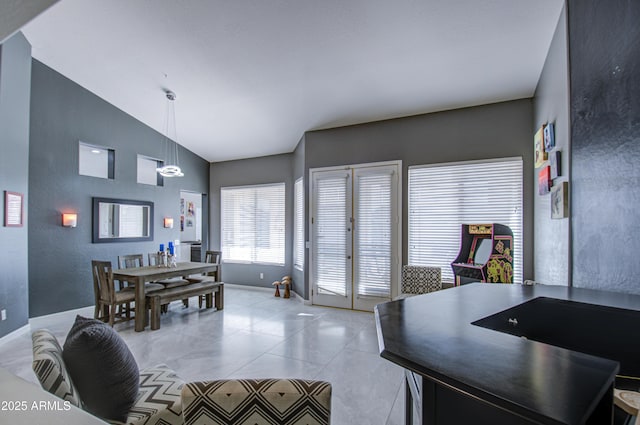 dining area with vaulted ceiling and light tile patterned floors